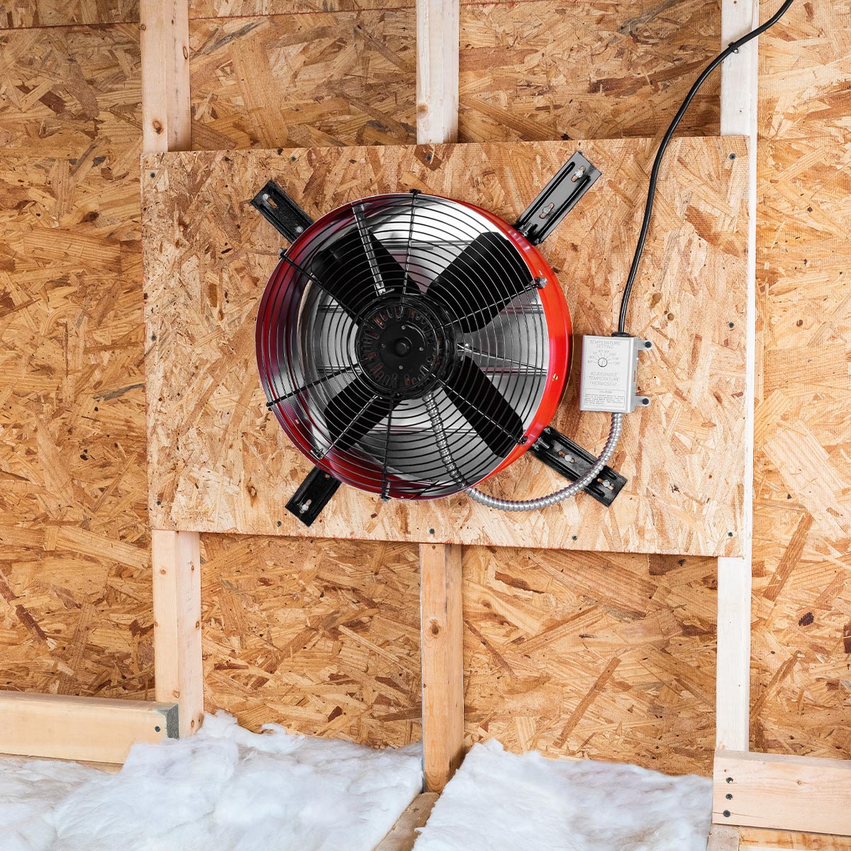 The premium exhaust fan in red installed in an attic gable end with the CX2121AM shutter to provide ventilation in your attic and protect your roofing components from heat damage.