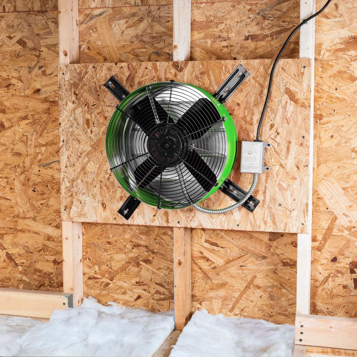 The premium exhaust fan in green installed in an attic gable end with the CX2121AM shutter to provide ventilation in your attic and protect your roofing components from heat damage.
