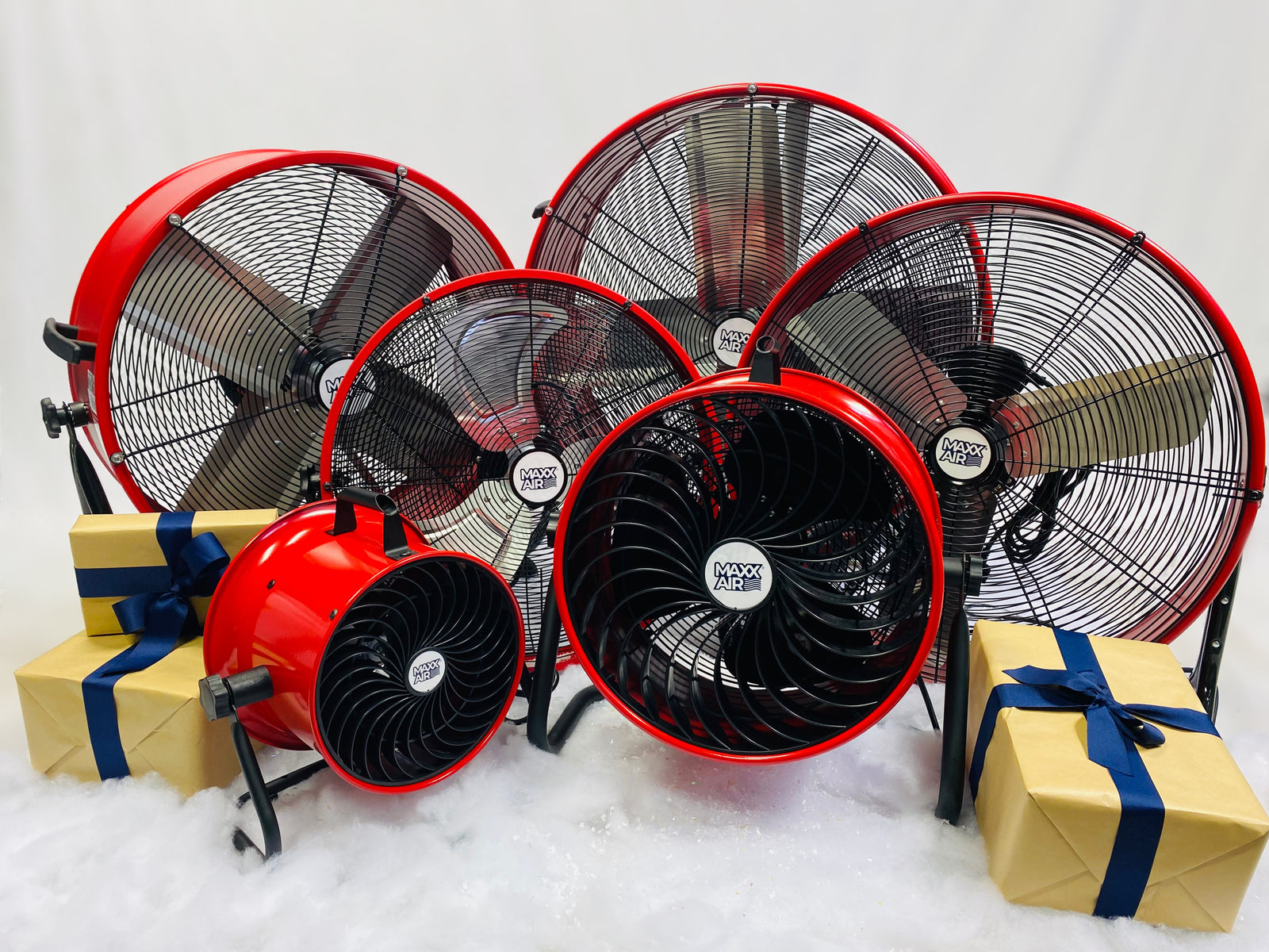 Our red Maxx Air series of drum and floor fans sit next to presents and snow for the holiday season. 