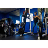 42 in. barrel fan cools a woman as she works out on a smith machine in a commercial gym.